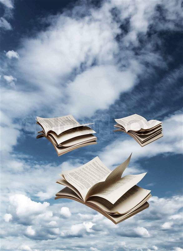 Three open books flying on blue sky, stock photo