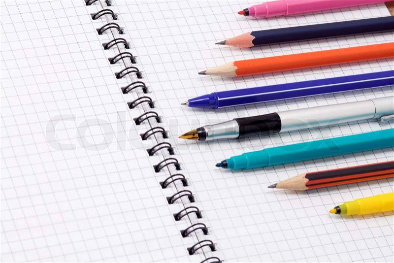 Pens and pencils on pad, stock photo