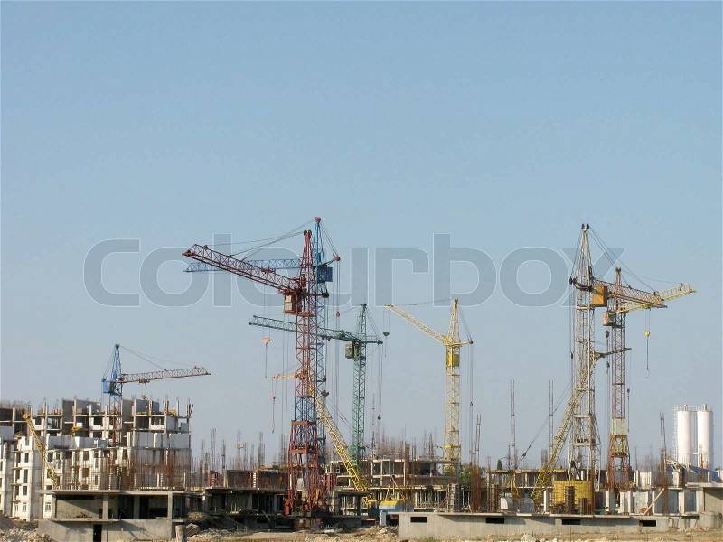 Building cranes on a construction yard, stock photo