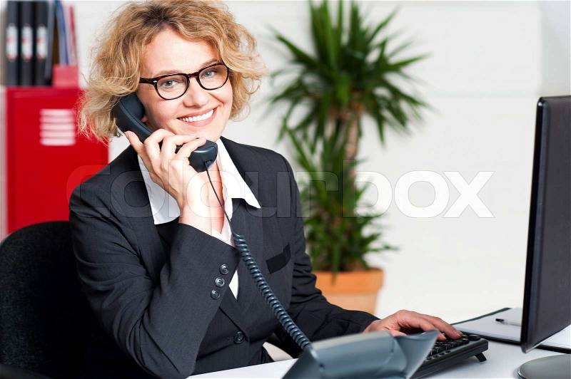 Front desk lady attending clients call, stock photo