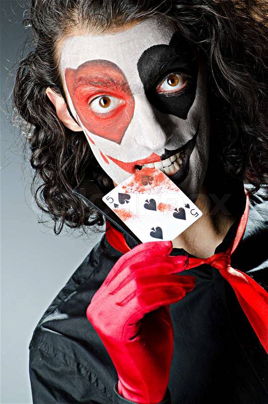 Joker with face mask in studio, stock photo