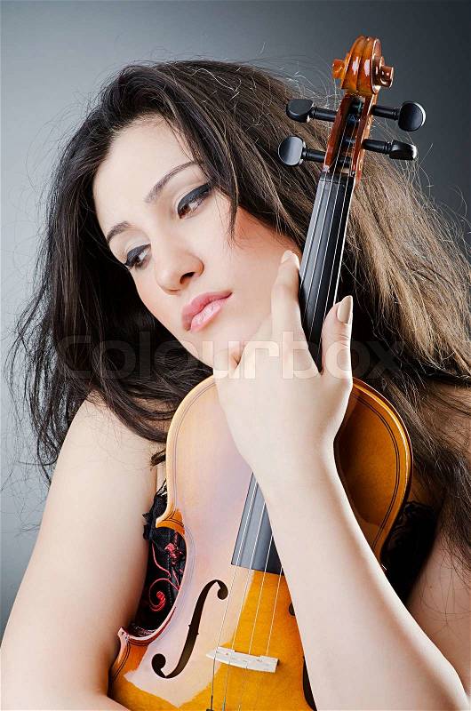 Female violin player against background, stock photo