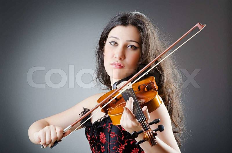 Female violin player against background, stock photo