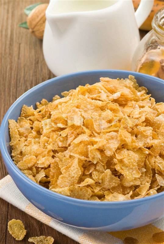 Bowl of corn flakes and milk on wood, stock photo