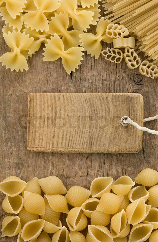Raw pasta and price tag label on wood, stock photo