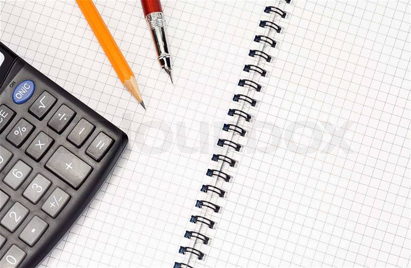 Pen and pencil on checked notebook, stock photo