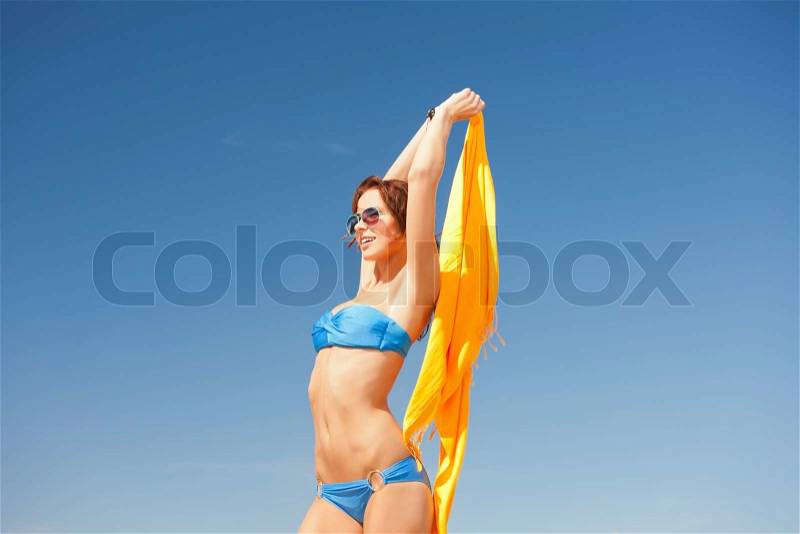 Happy woman with yellow sarong on the beach, stock photo