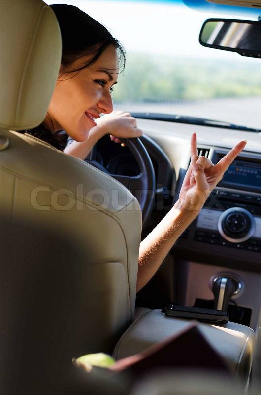 Woman giving heavy metal horns sign, stock photo