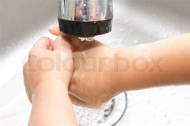 Boy washes his hands, stock photo