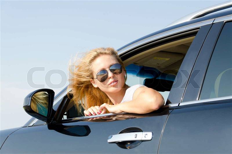 Woman looking back from the car window, stock photo