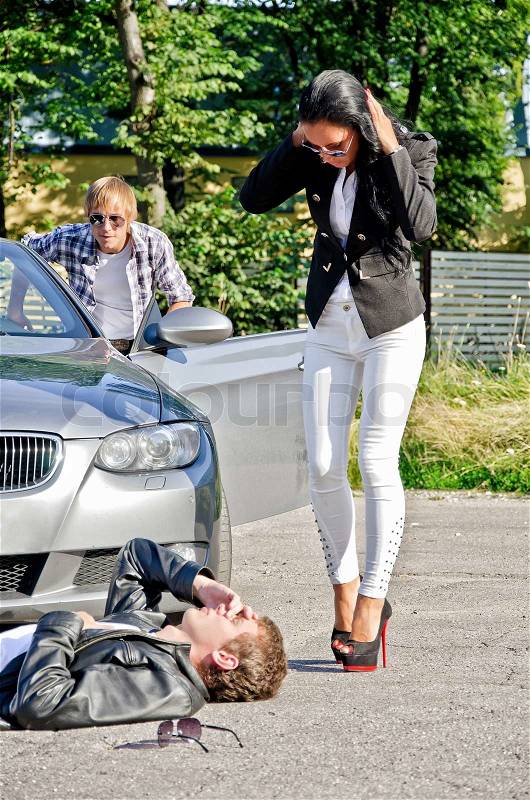 Male thief stealing a car while his accomplice distracts female driver, stock photo