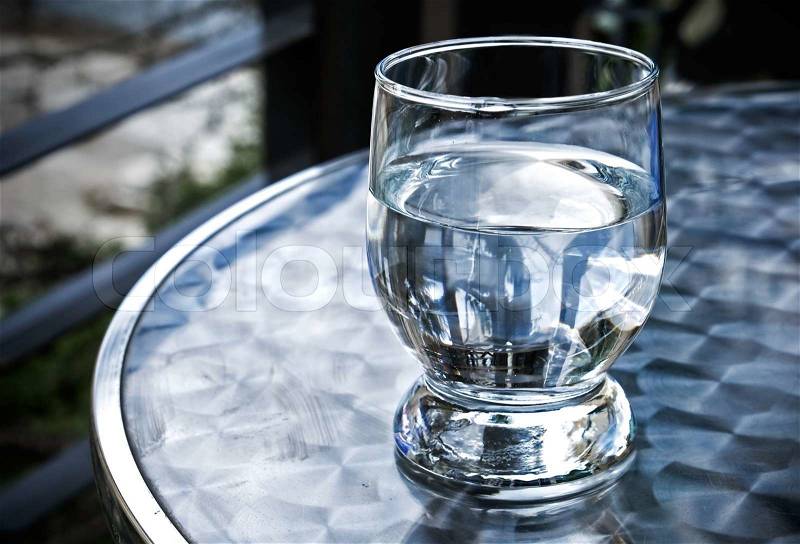 Glass of water on the metal table, stock photo