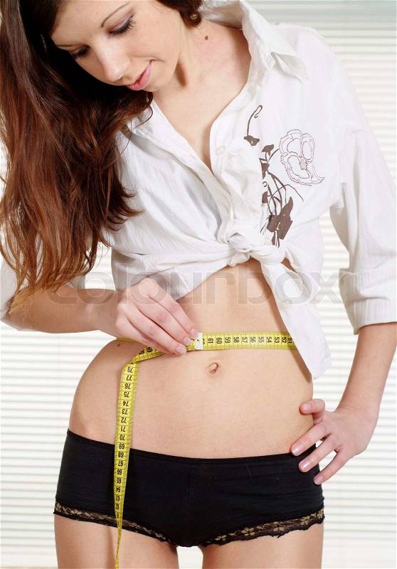 Luck Caucasian woman measuring her waist measuring tape, stock photo