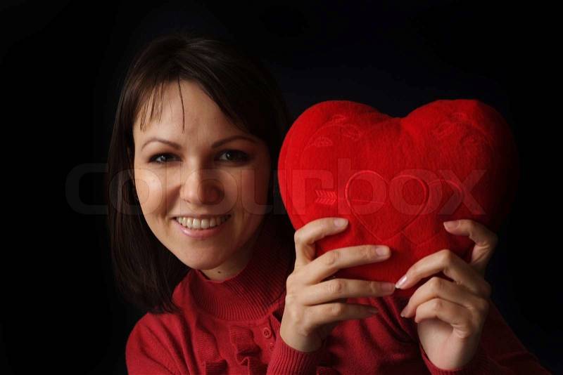Good Caucasian woman with a happy heart pillow, stock photo