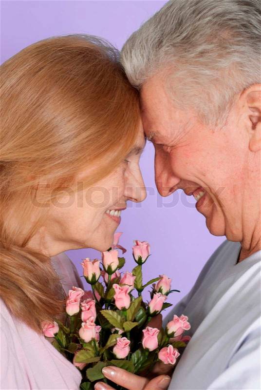 Happy Caucasian elderly people stand together with the flower, stock photo