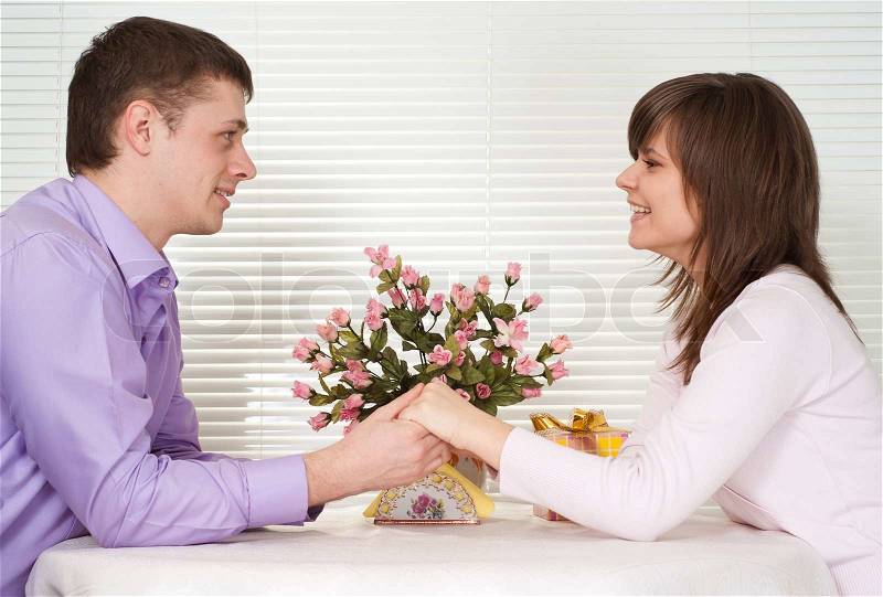 Pretty Caucasian couple sitting at a table in a cafe, stock photo