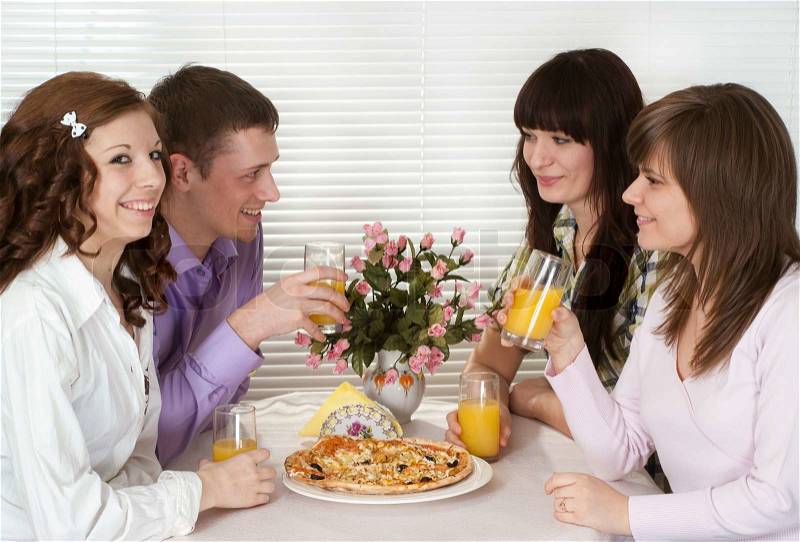 Beautiful Caucasian charming company of four people sit and eat pizza, stock photo