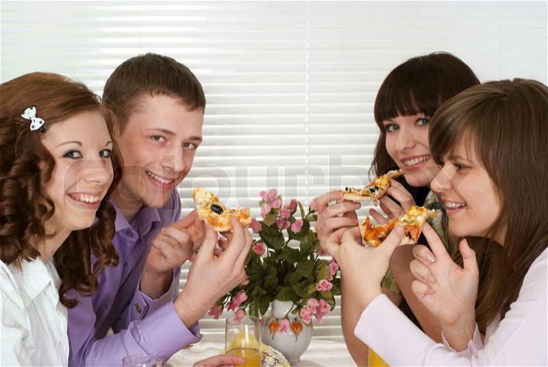 Happy Caucasian charming company of four people sit and eat pizza, stock photo