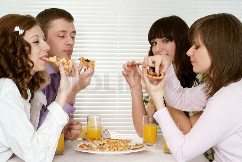 Good Caucasian charming company of four people sit and eat pizza, stock photo