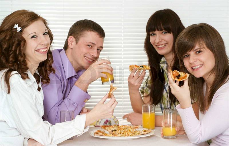 Beautiful charming company of four people sit and eat pizza, stock photo