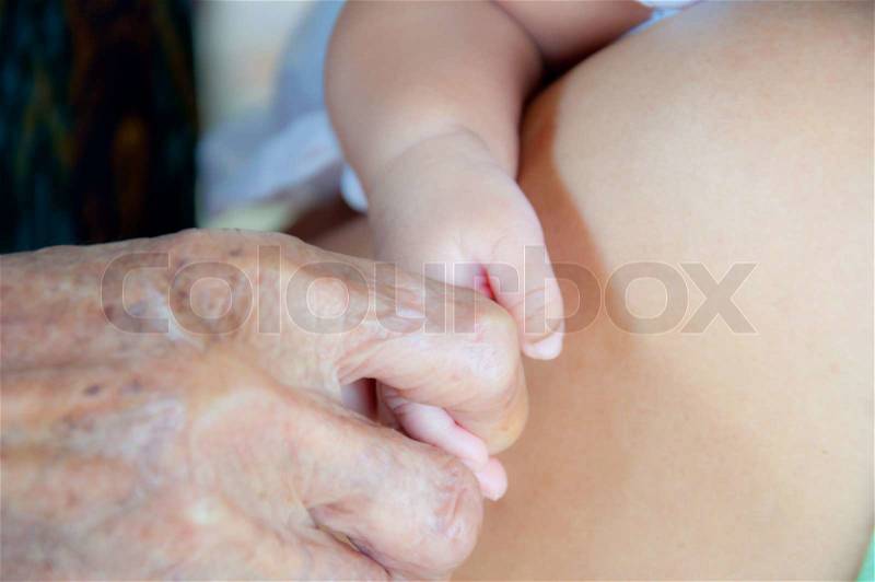 Baby hand and old woman hand, stock photo