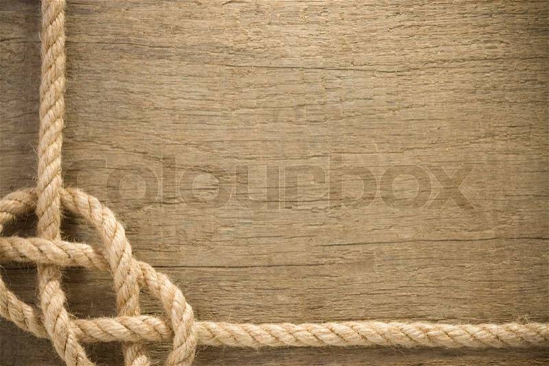 Ship ropes with knot on wood background, stock photo