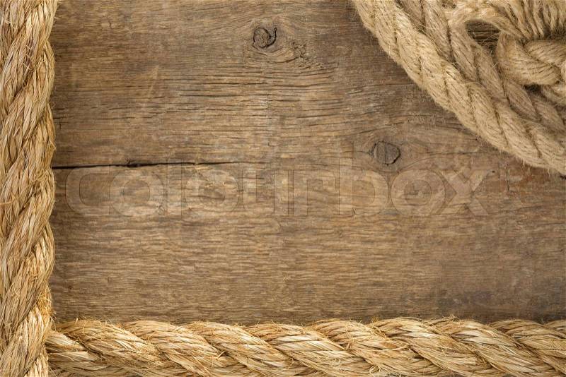 Ship ropes and knot on wood background, stock photo