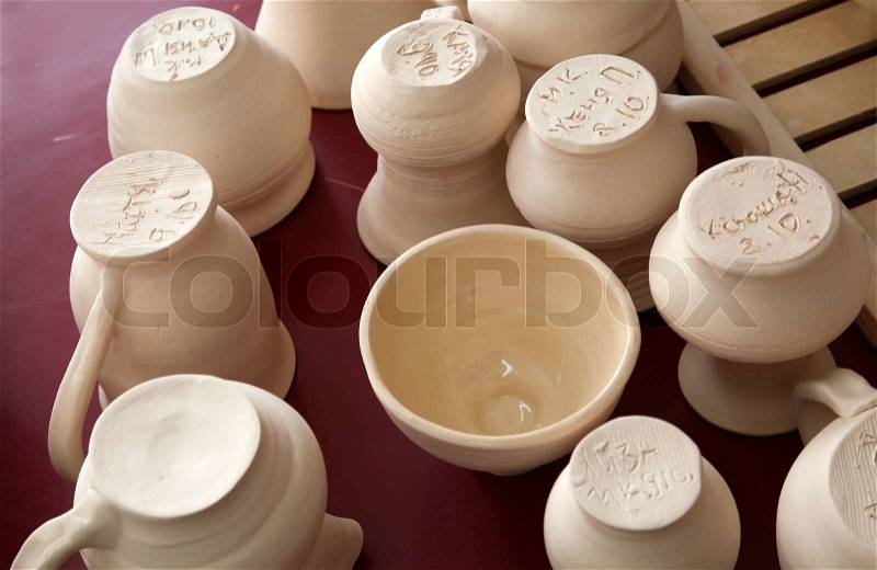 Pottery examples with artists initials and dates on the shelf in the art school, stock photo