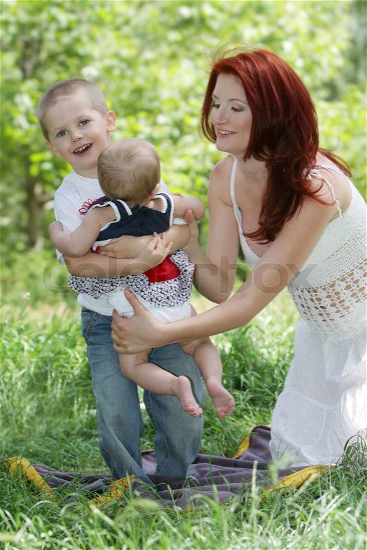 Happy mother and two children on natural background, stock photo