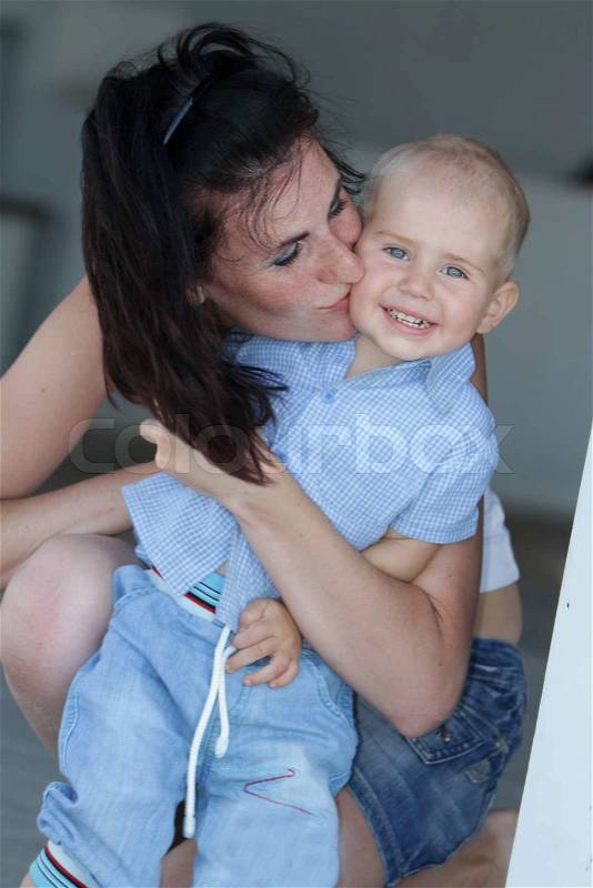 Outdoor portrait of young happy mother playing with child on natural background, stock photo