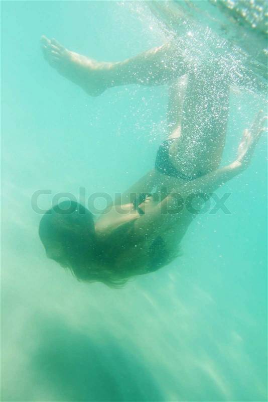 Young woman swiming underwater in sea or pool, stock photo