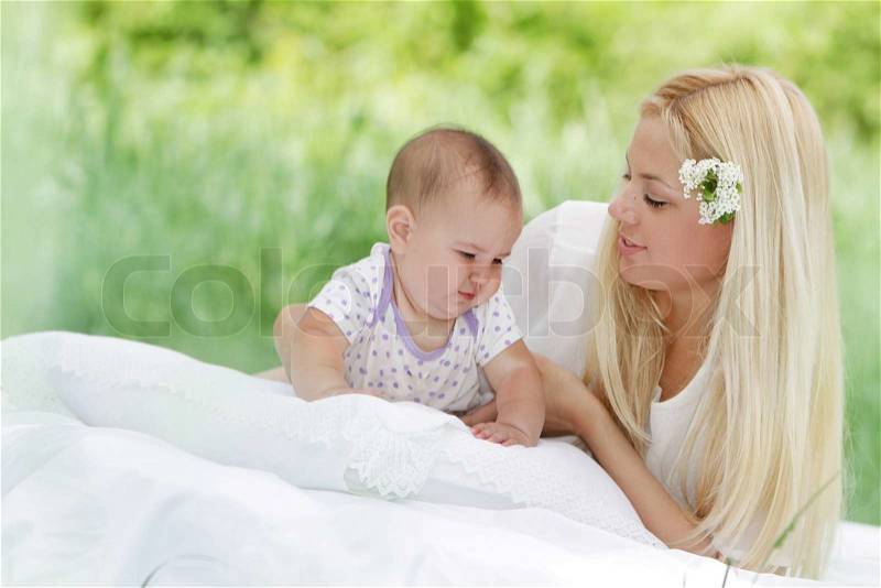 Young happy mother and baby child on natural background, stock photo