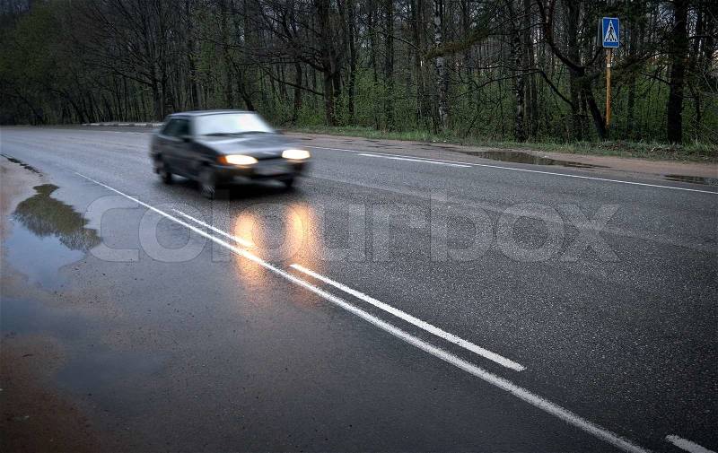 On the wet road with fast approaching cars Photo with shallow depth of field, stock photo