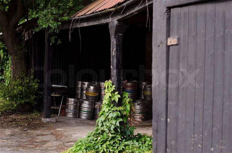 A cache of metal beer barrels in a pub porch, stock photo