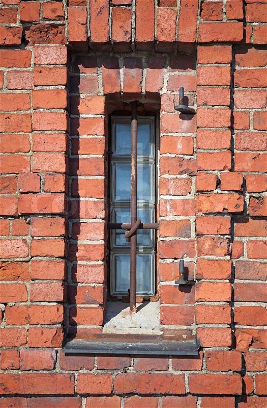 Brick wall of an old building with small rectangle window, stock photo