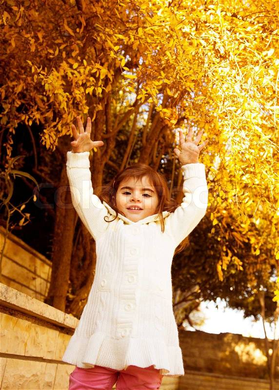 Small girl in autumn backyard, stock photo