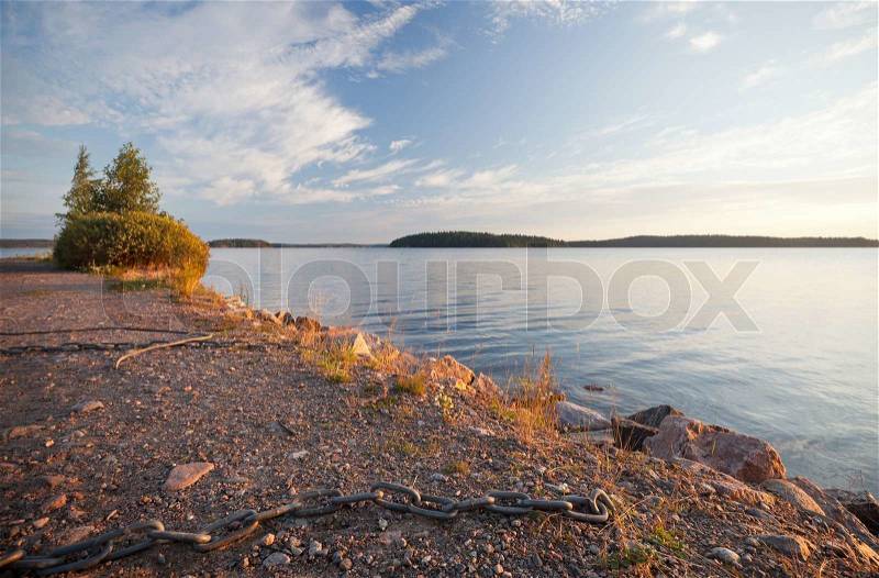 Black ships chain on the coast of Saimaa lake, Finland, stock photo
