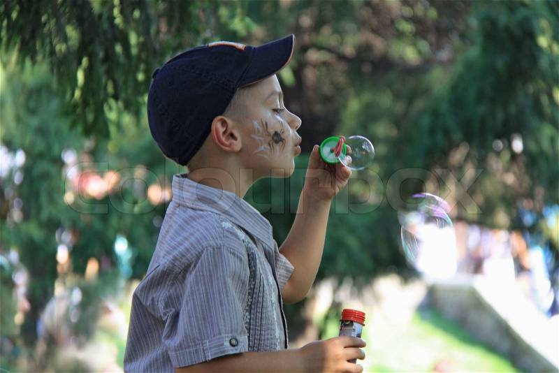 Boy making soap bubbles, stock photo
