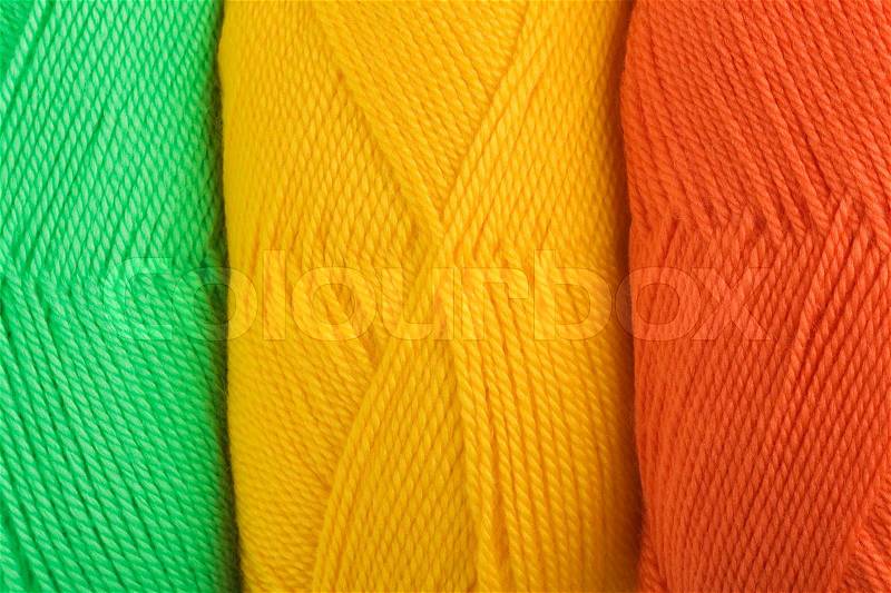 Background of yarn skeins in yellow, orange and green colors, stock photo