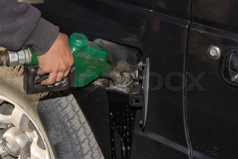 Male hand refilling the car with fuel on a filling station, stock photo