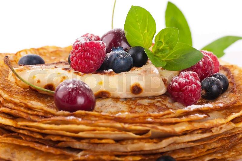 Pancakes with berries and mint on a white background, stock photo