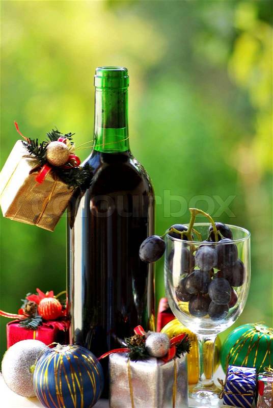 Decorated bottle of red wine with Christmas presents, stock photo