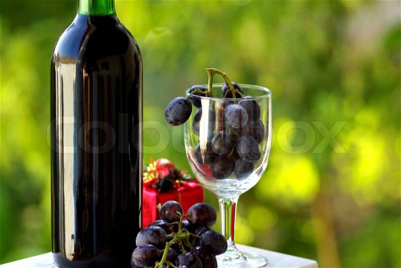 Decorated bottle of red wine with Christmas presents, stock photo