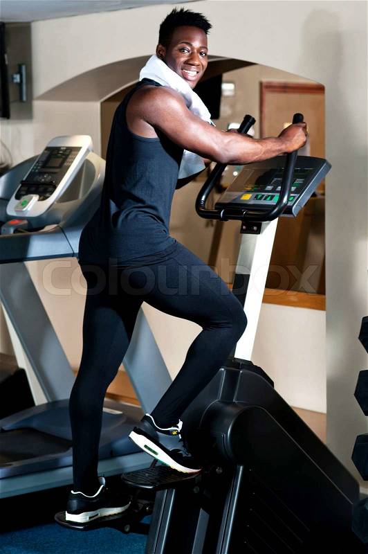 Young smiling fit african male burning calories, stock photo