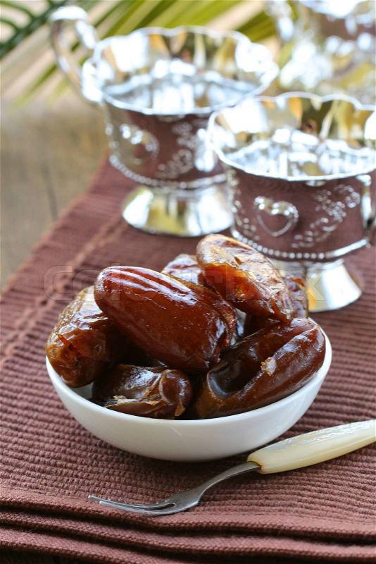 Sweet dates in bowl on a natural background, stock photo