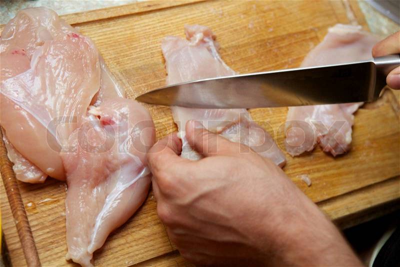 Cutting chicken meat, stock photo
