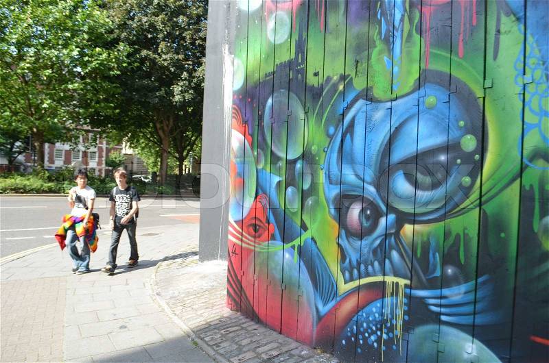 People walking near street art monster in downtown Bristol, stock photo