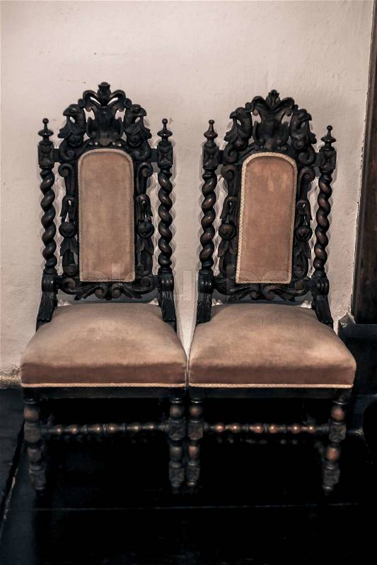Antique gothic chairs up against the wall, stock photo