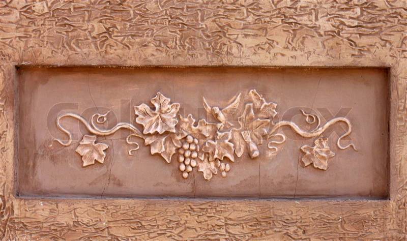 Decoration of wall: bas-relief of vine, stock photo