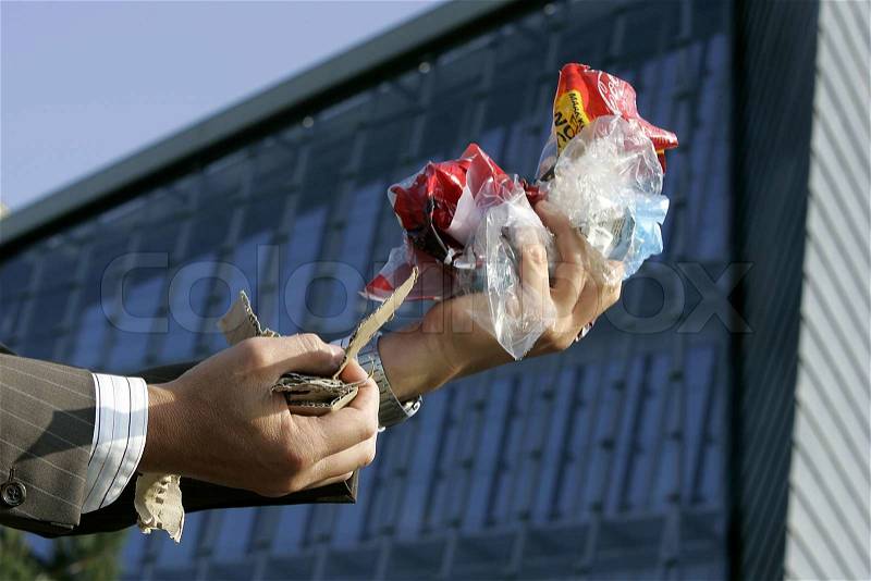 Two hands one with paper waste one with plastic waste, stock photo